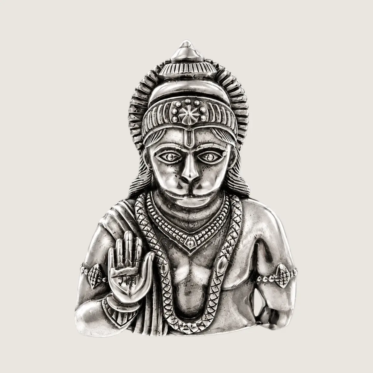 Silver statue of a deity on a light gray background