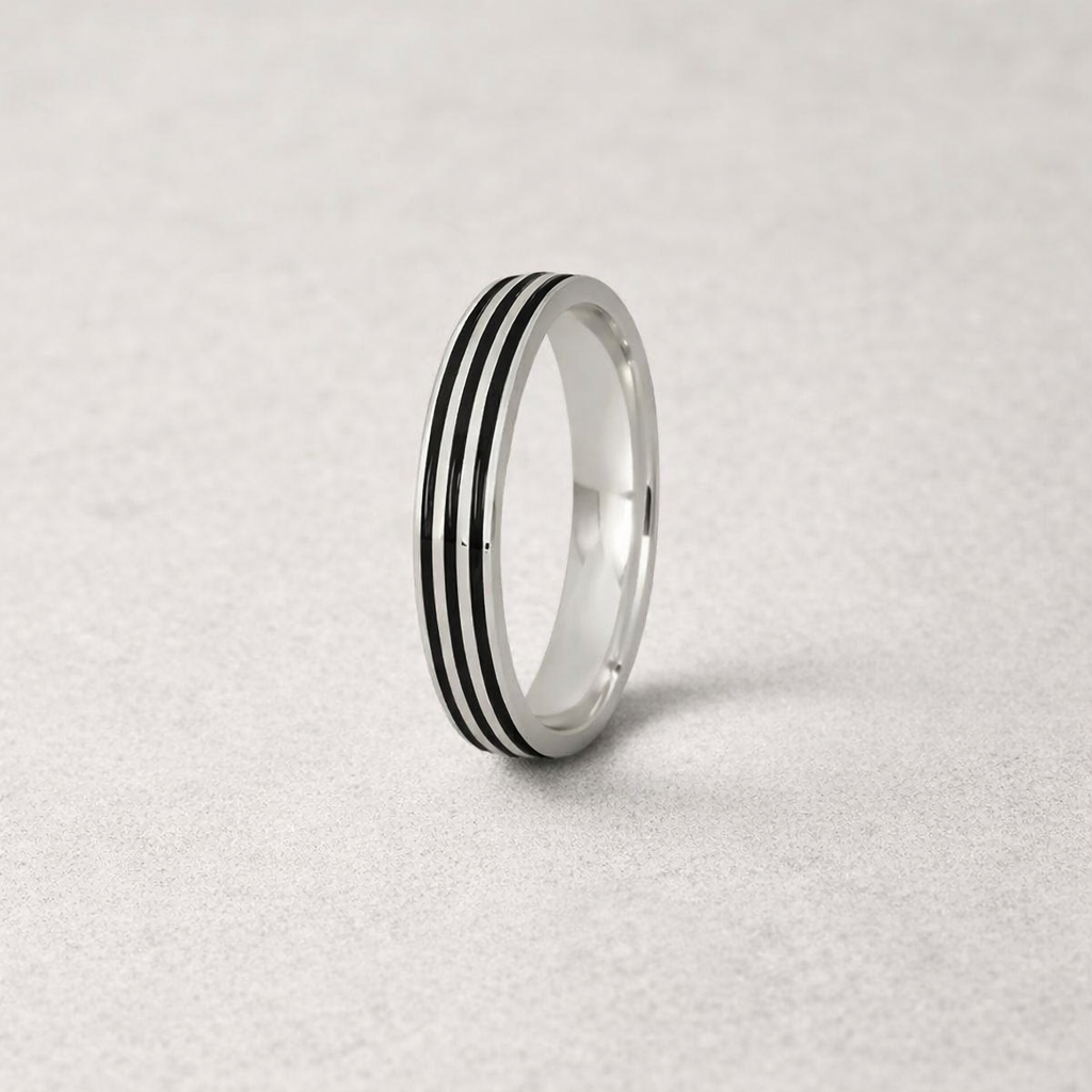 Silver ring with black stripes on a light gray background