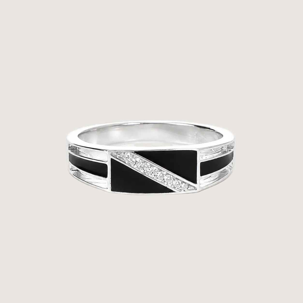 Silver ring with black and diamond accents on a beige background