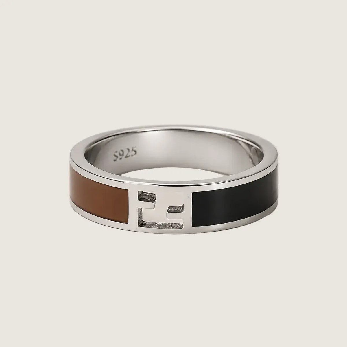 Silver ring with brown and black inlay on a light beige background