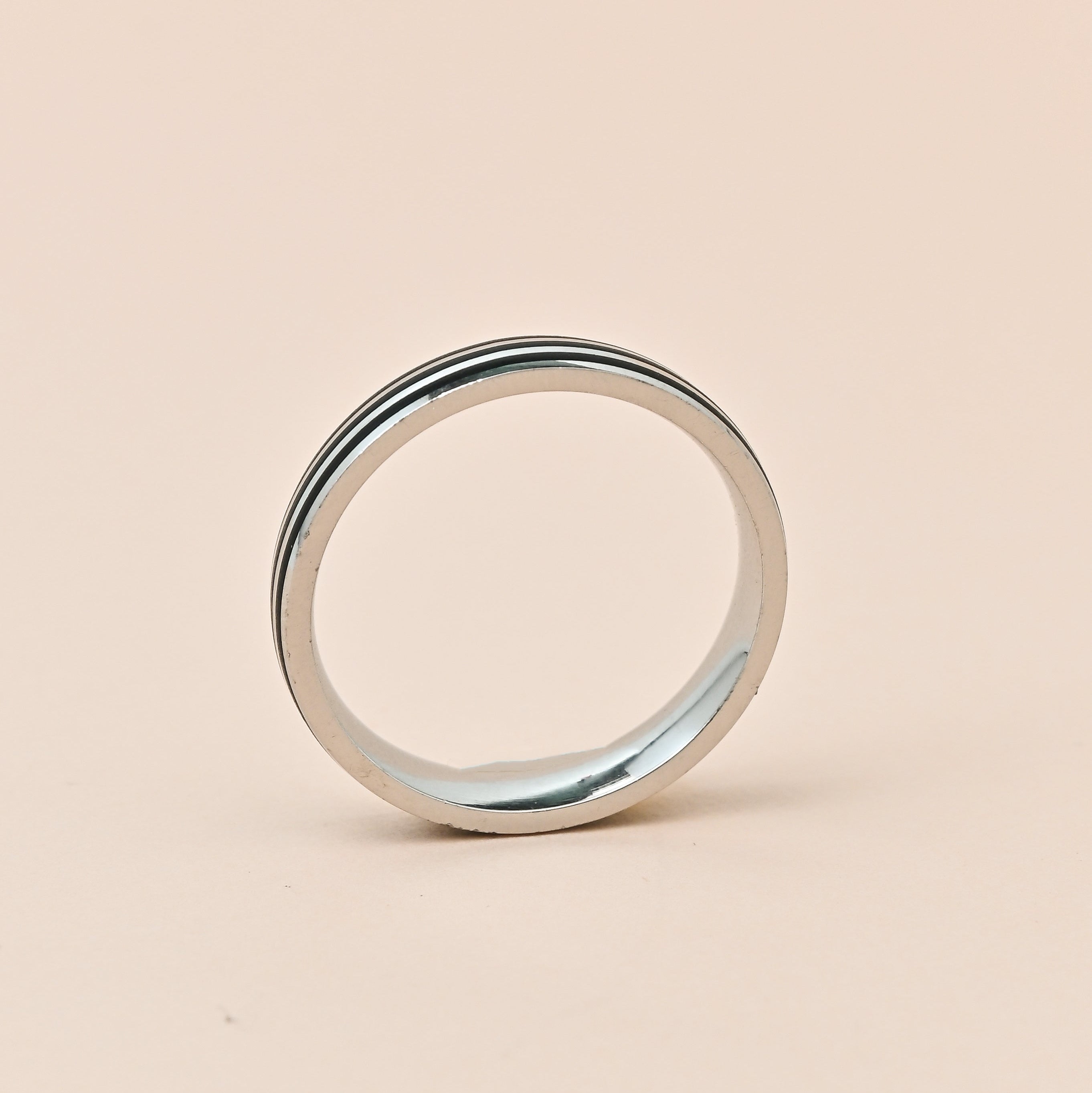 Silver ring on a beige background with 'TRISHNHA' branding.
