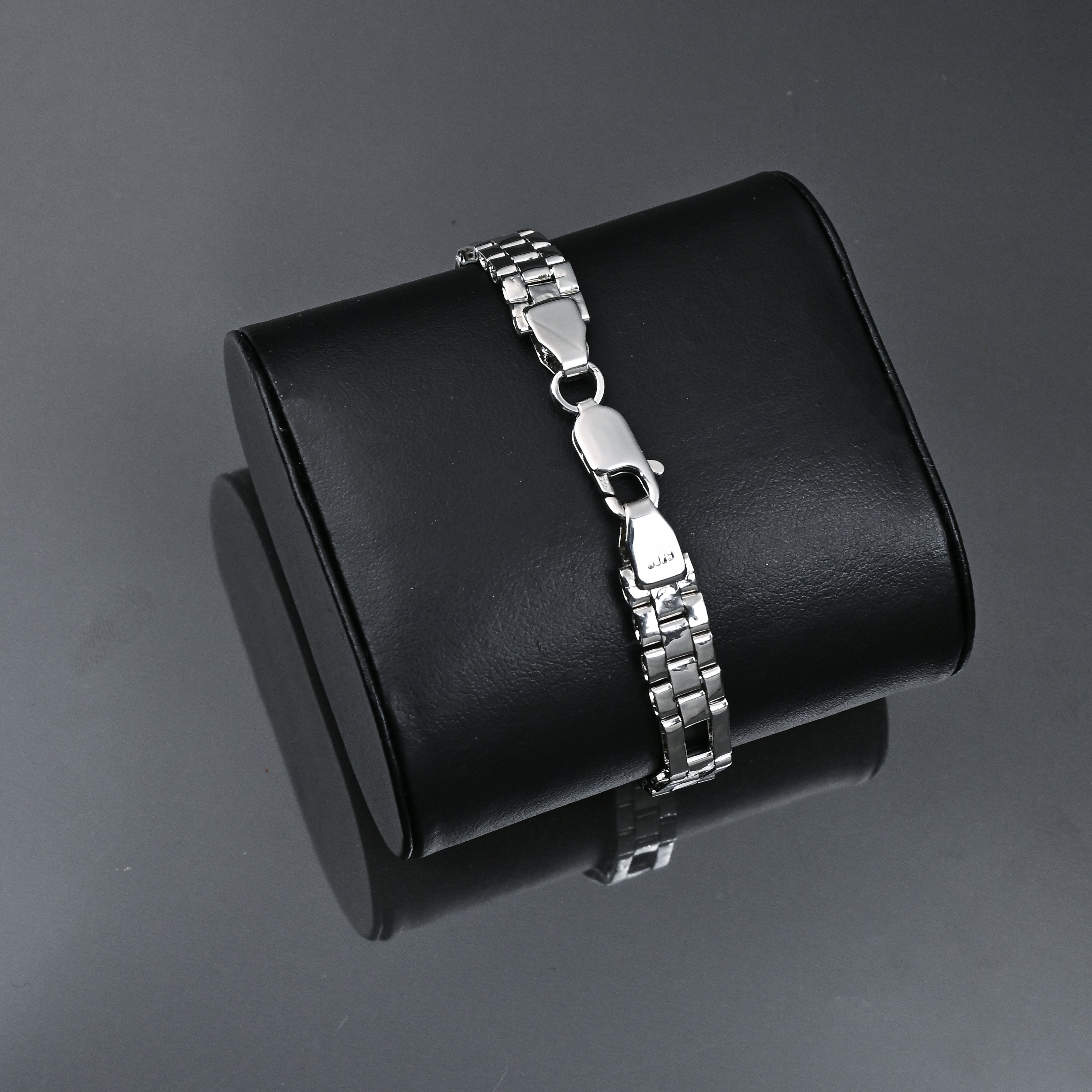 Silver bracelet on a black box with 'TRISHNHA' branding on a dark background