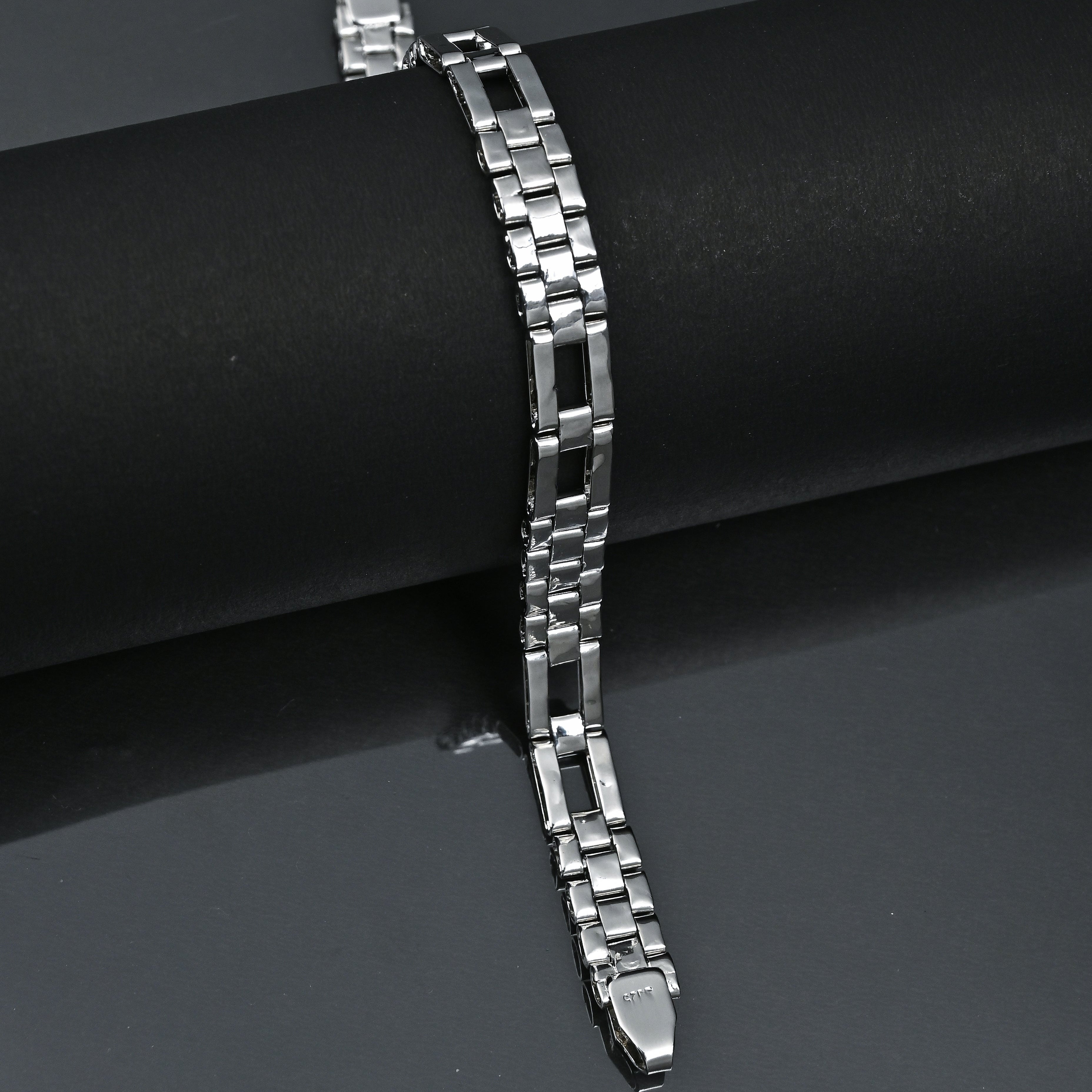 Silver bracelet on a black cylindrical object with 'TRISHNHA' branding.