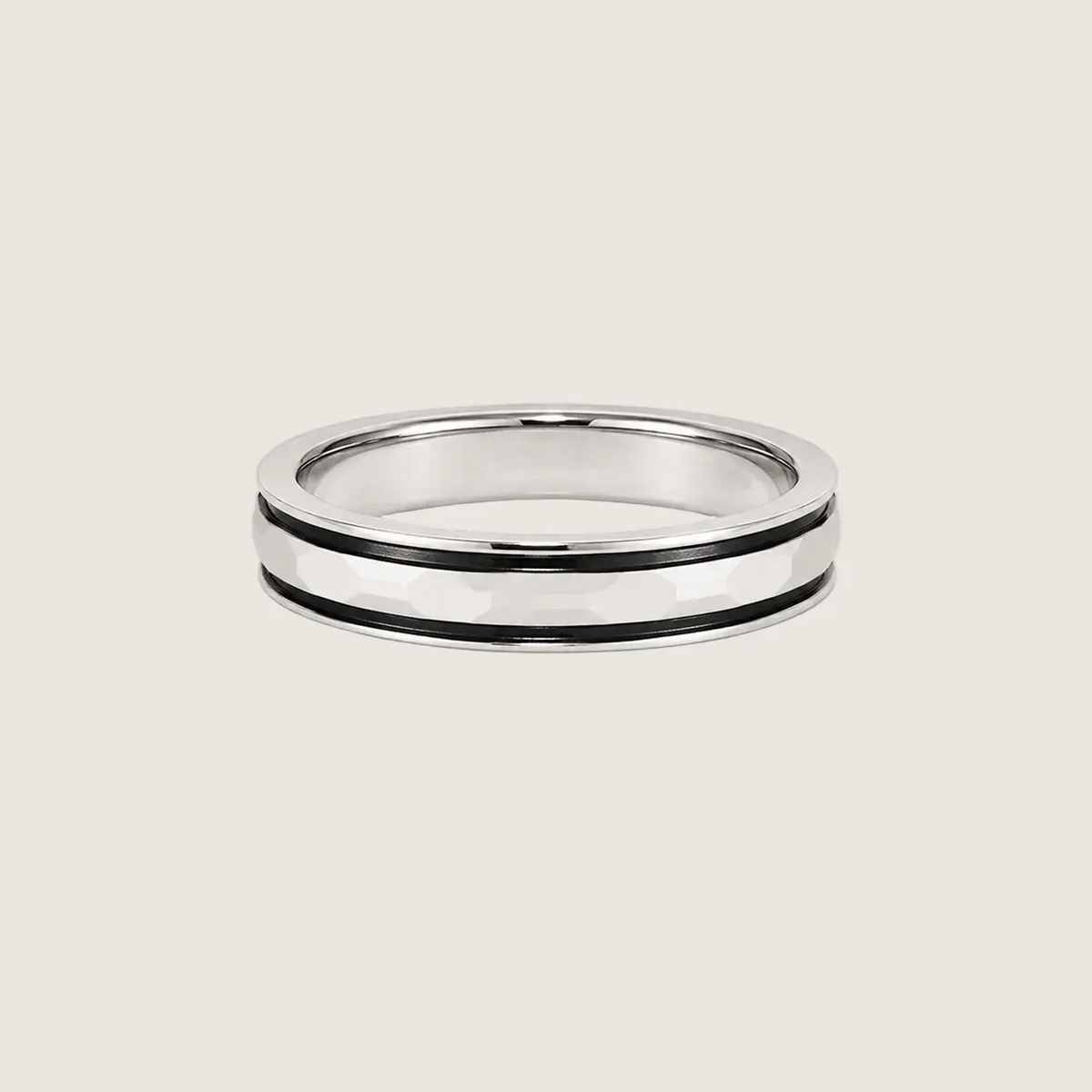Silver ring with black inlay on a beige background