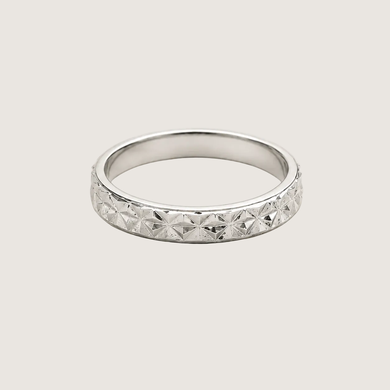 Silver ring with diamond-like stones on a light gray background