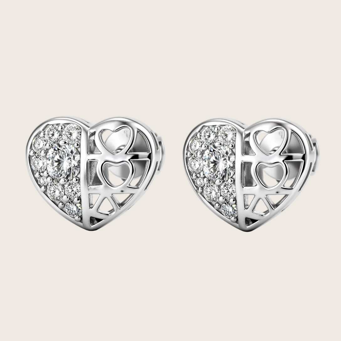 Heart-shaped silver earrings with embedded stones on a white background