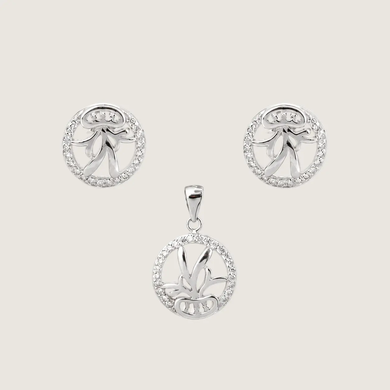 Silver jewelry set with pendant and earrings on a light beige background