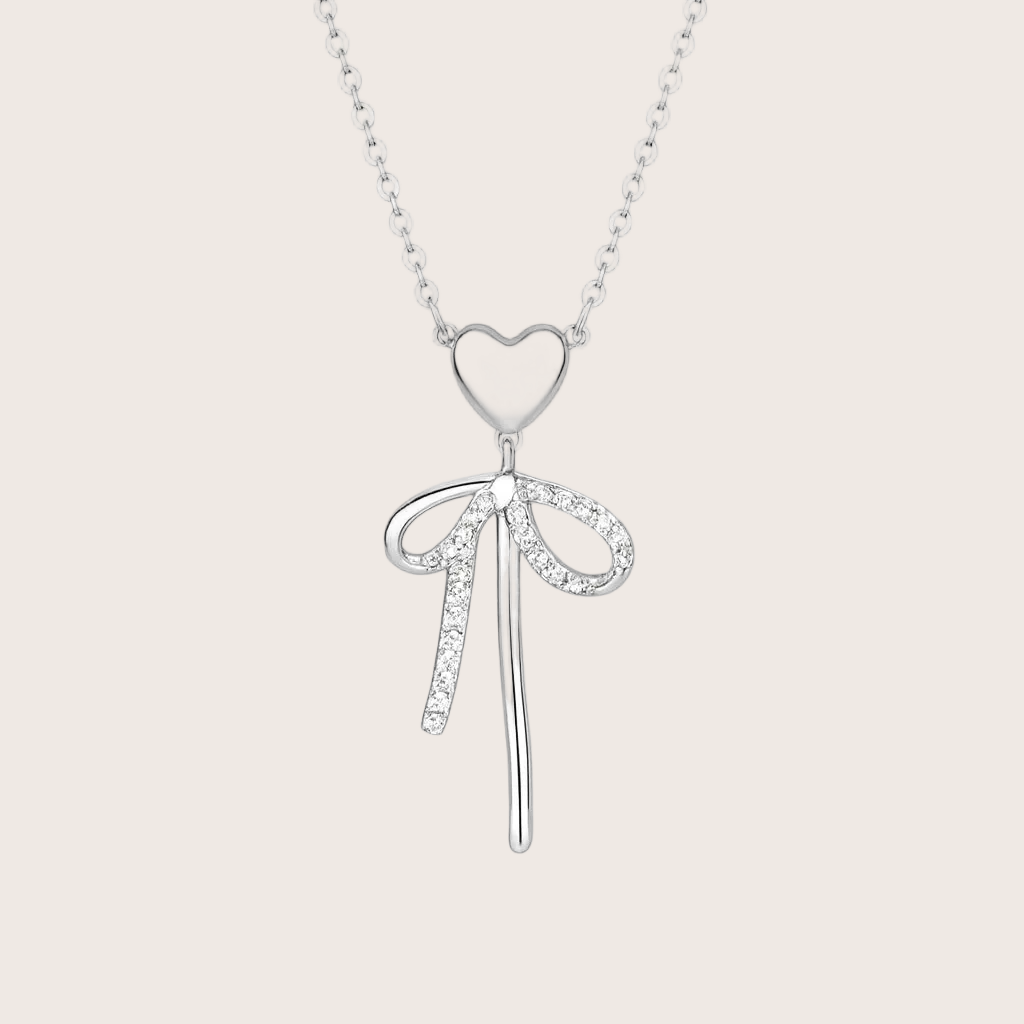Silver bow-shaped pendant necklace on a white background