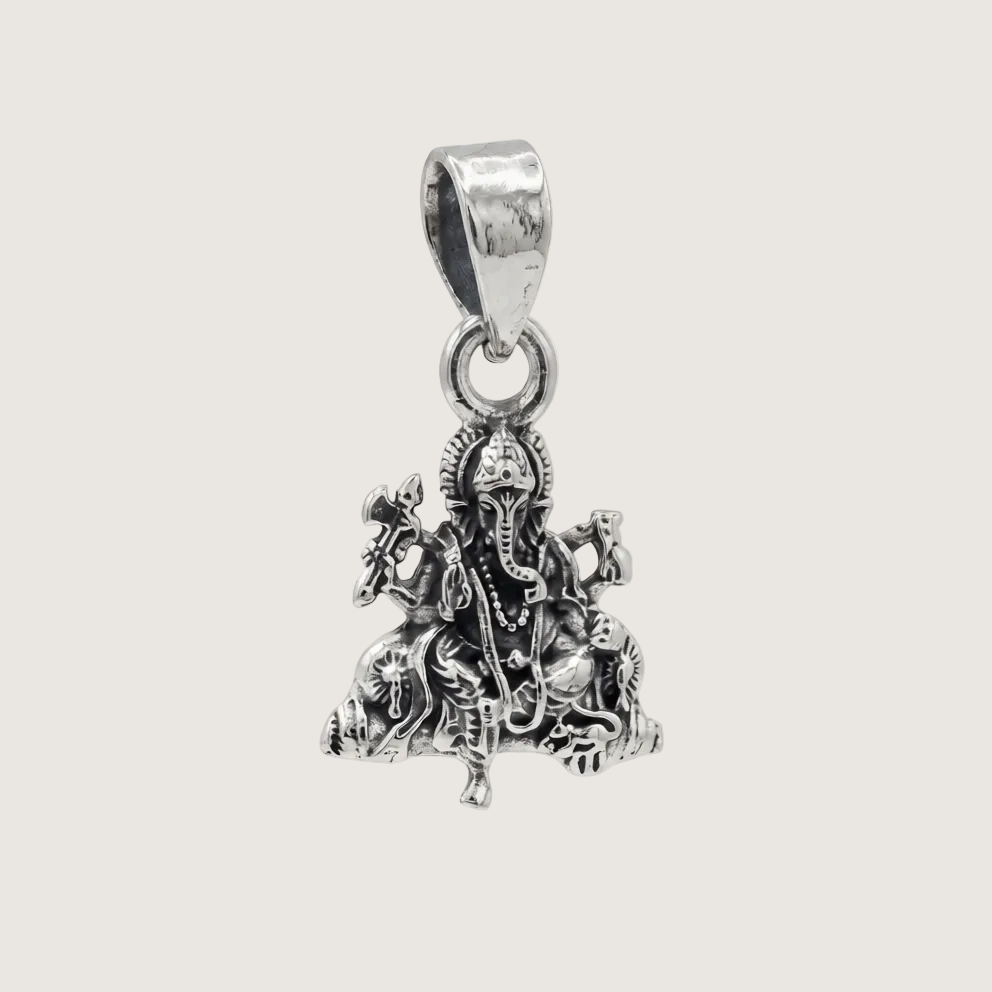 Silver pendant with intricate design on a light gray background