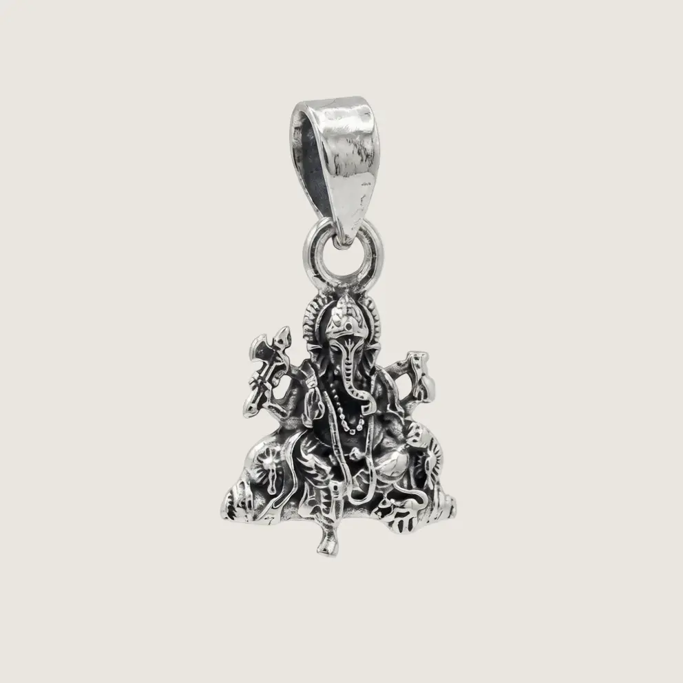 Silver pendant with intricate design on a light gray background