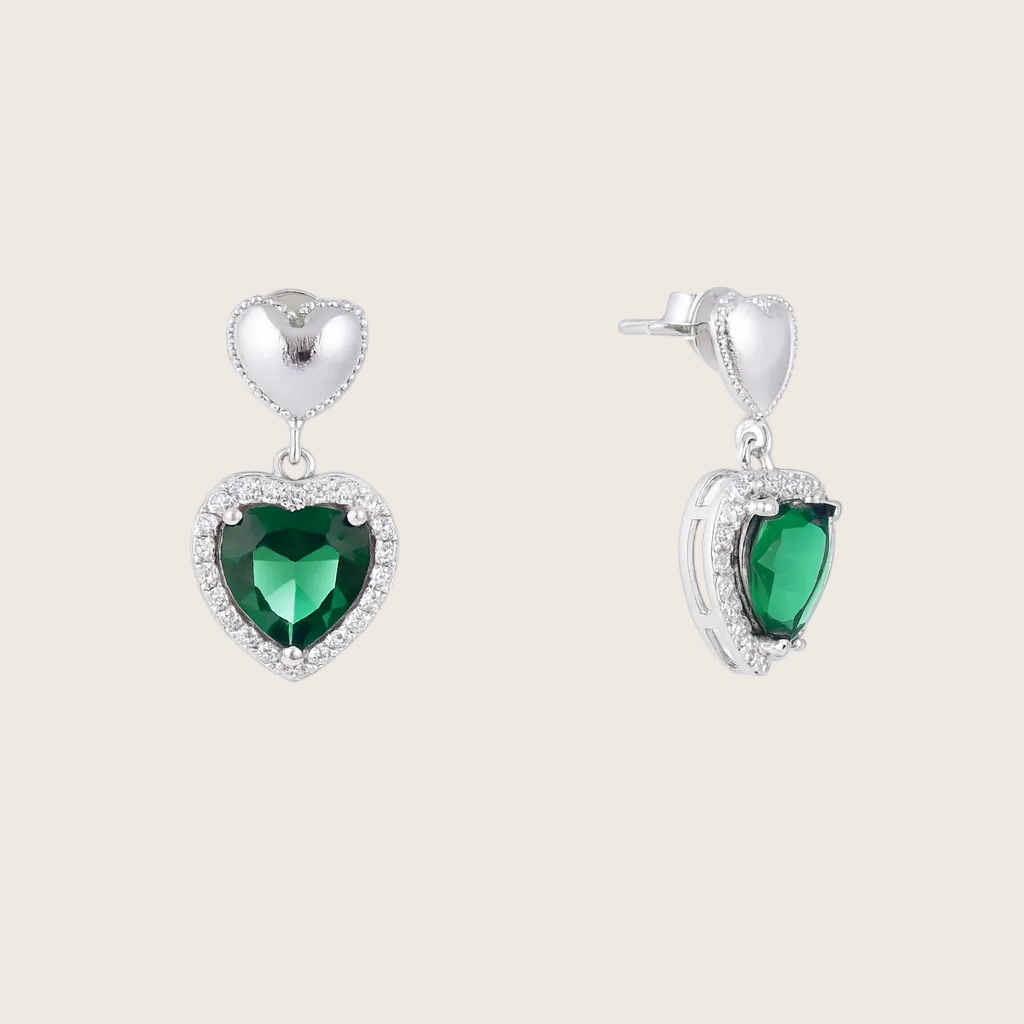 Pair of earrings with heart-shaped green gemstones on a white background