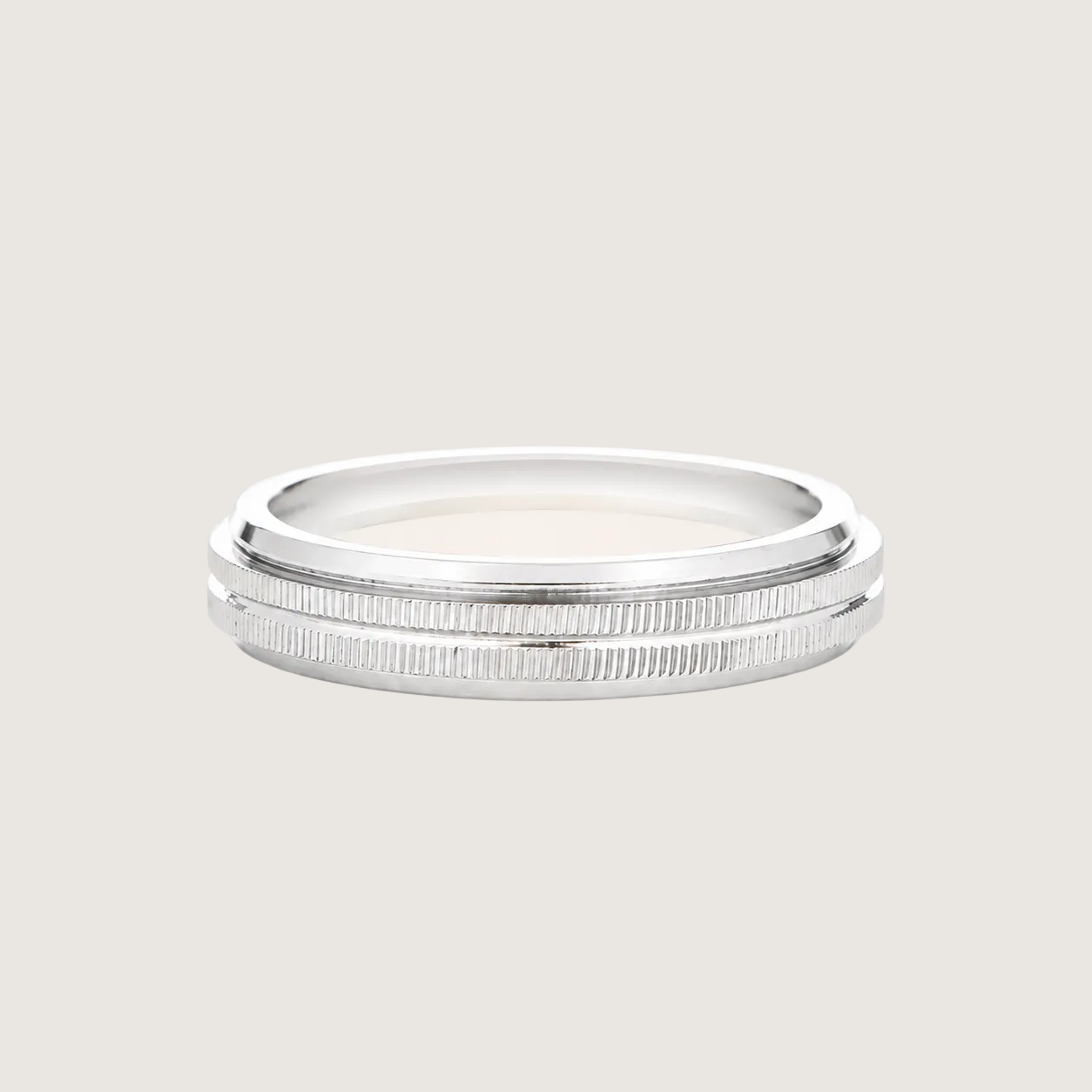 Silver ring with a textured band on a light beige background