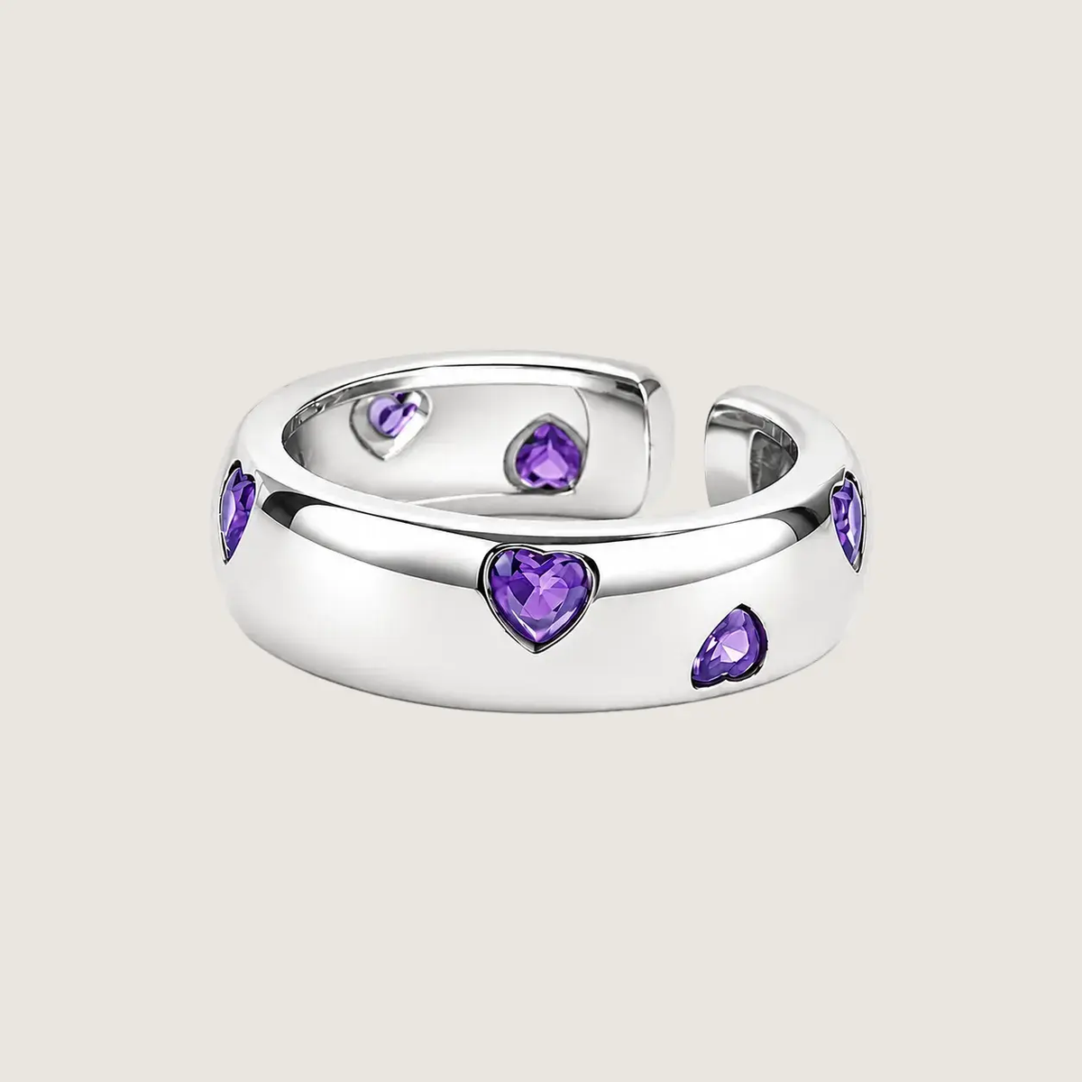 Silver ring with purple heart-shaped gemstones on a light pink background