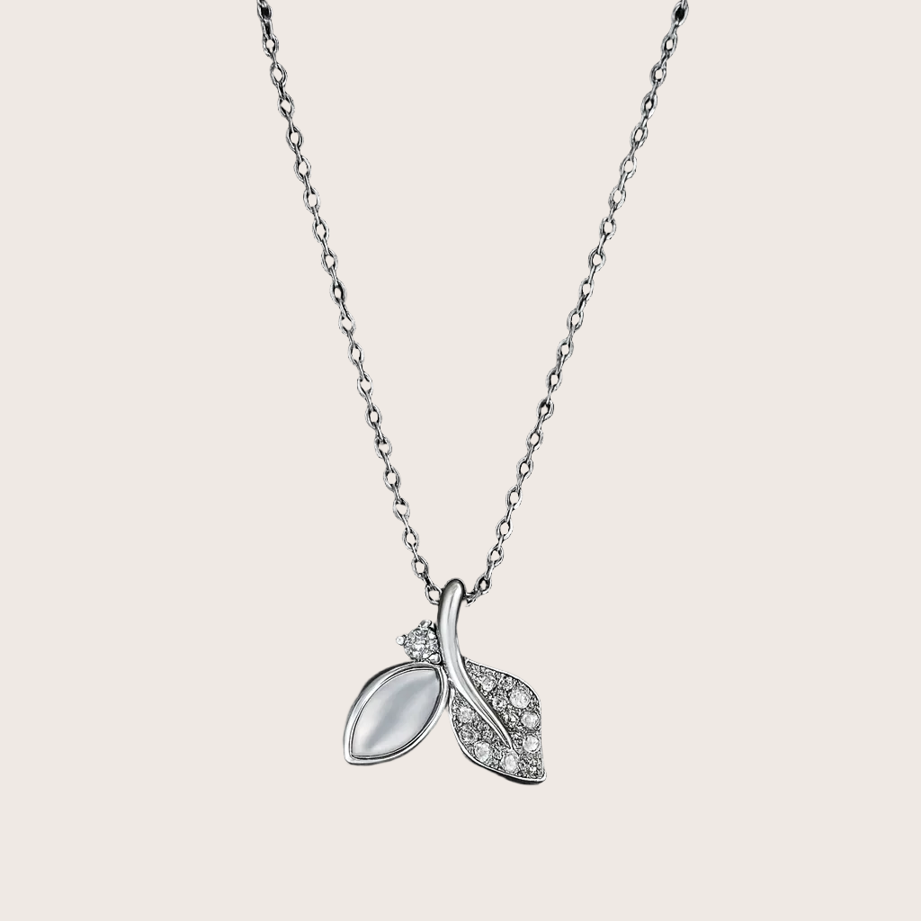 Silver necklace with a leaf-shaped pendant on a black background
