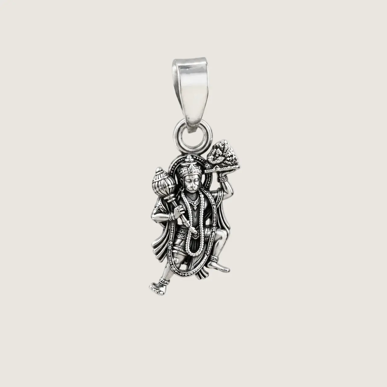 Silver pendant with a deity figure on a light beige background