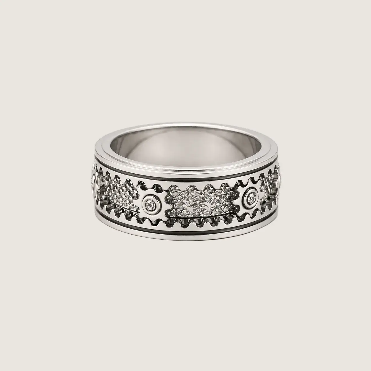 Silver ring with intricate design on a light beige background