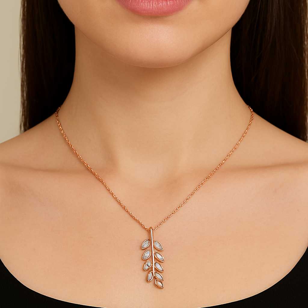 Rose gold necklace with leaf pendant on a model against a neutral background