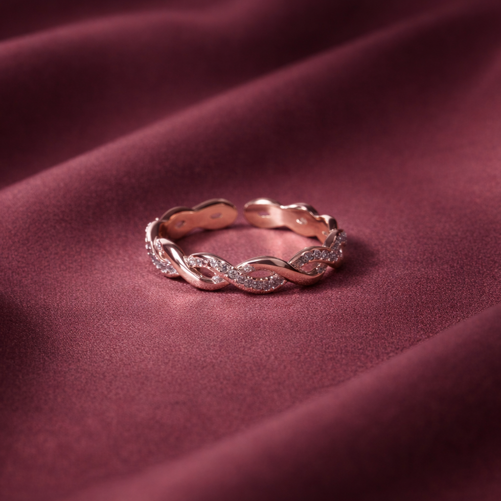 Rose gold ring with small diamonds on a maroon fabric background