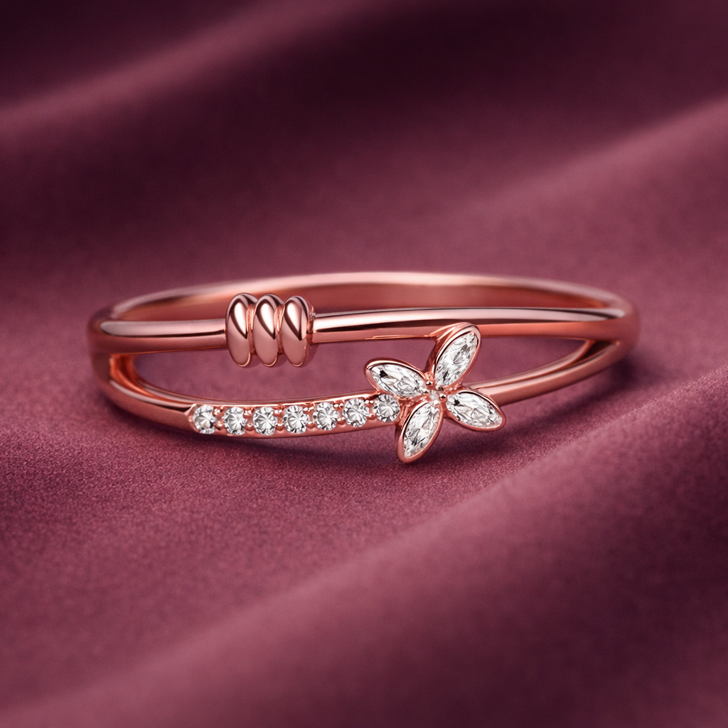 Rose gold ring with bow design on a maroon fabric background