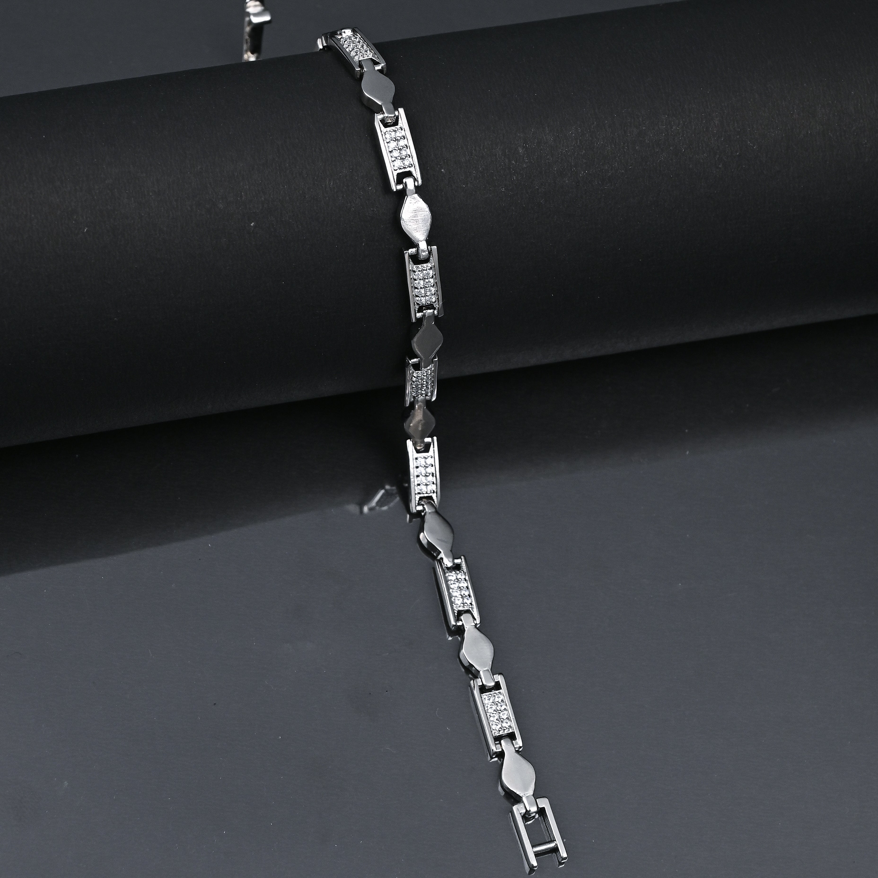Silver bracelet on a black background with 'TRISHNHA' branding.