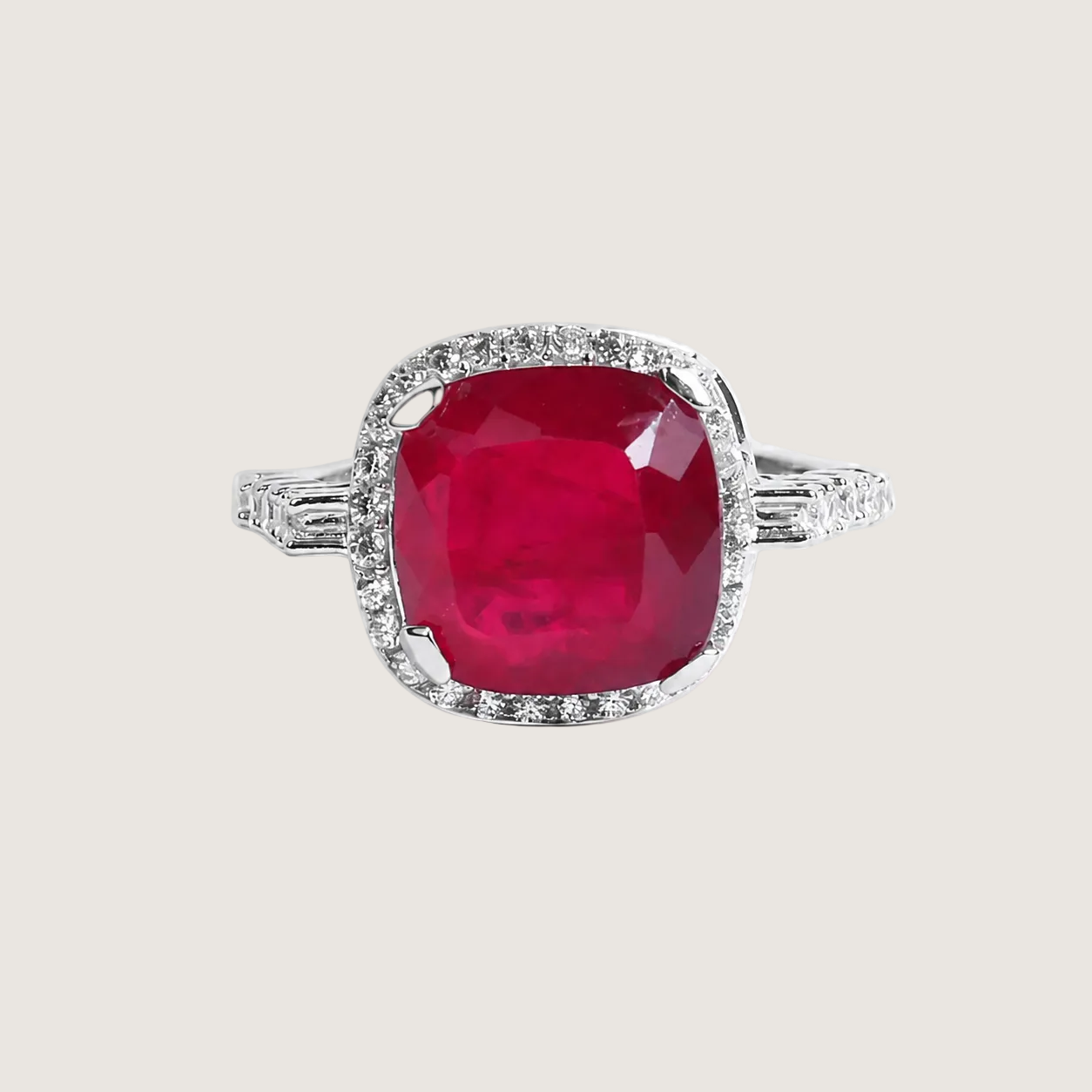 Ring with a red gemstone and diamond accents on a light beige background