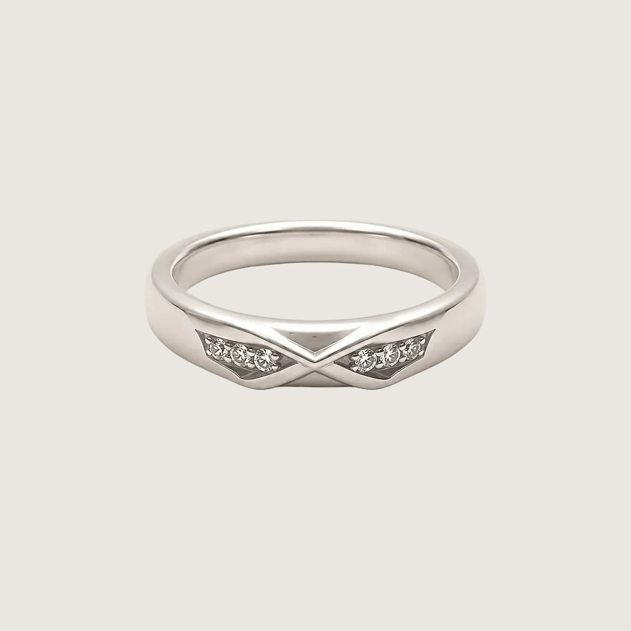 Silver ring with small diamonds on a beige background