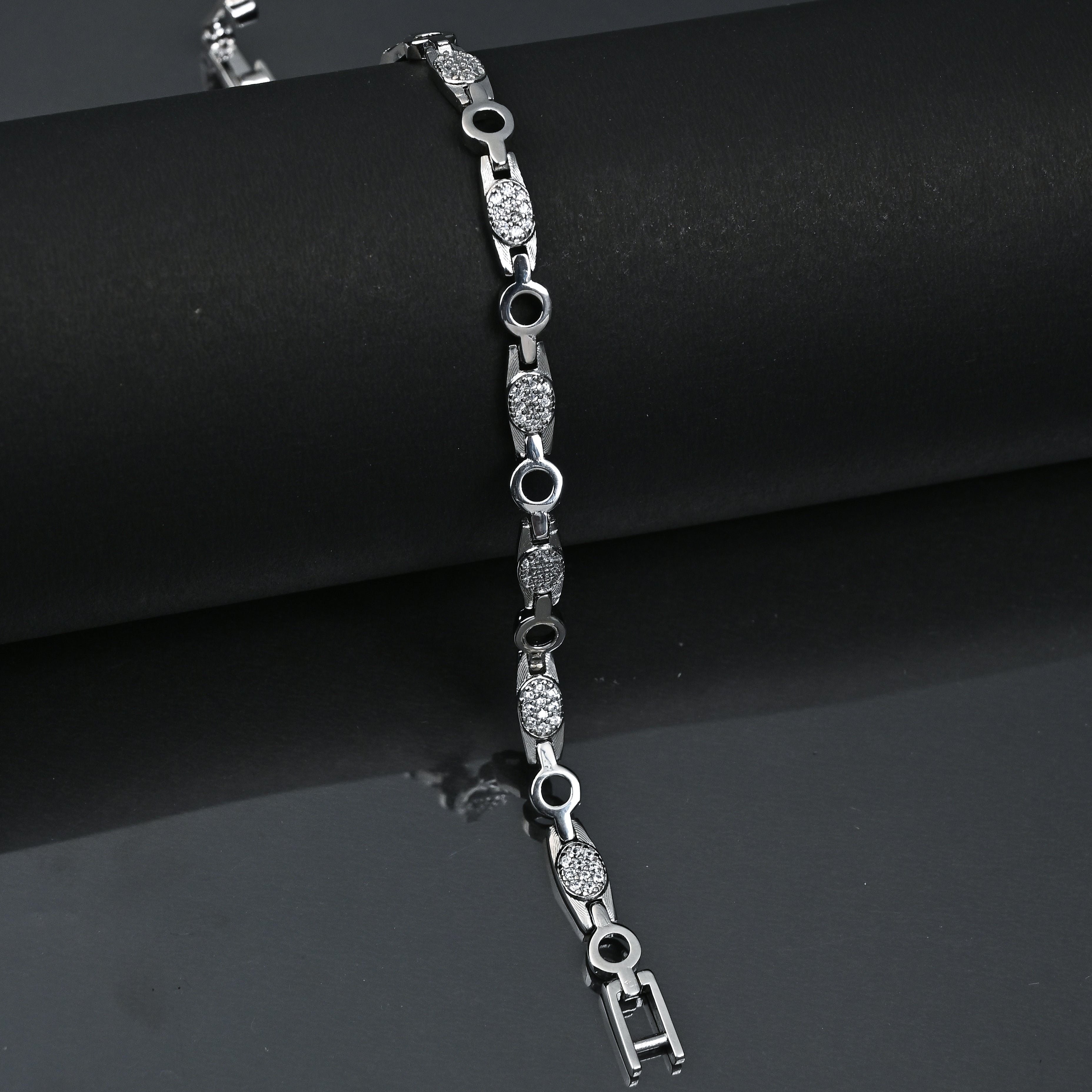 Silver bracelet with diamond accents on a black background, featuring the brand 'Trishhna'.