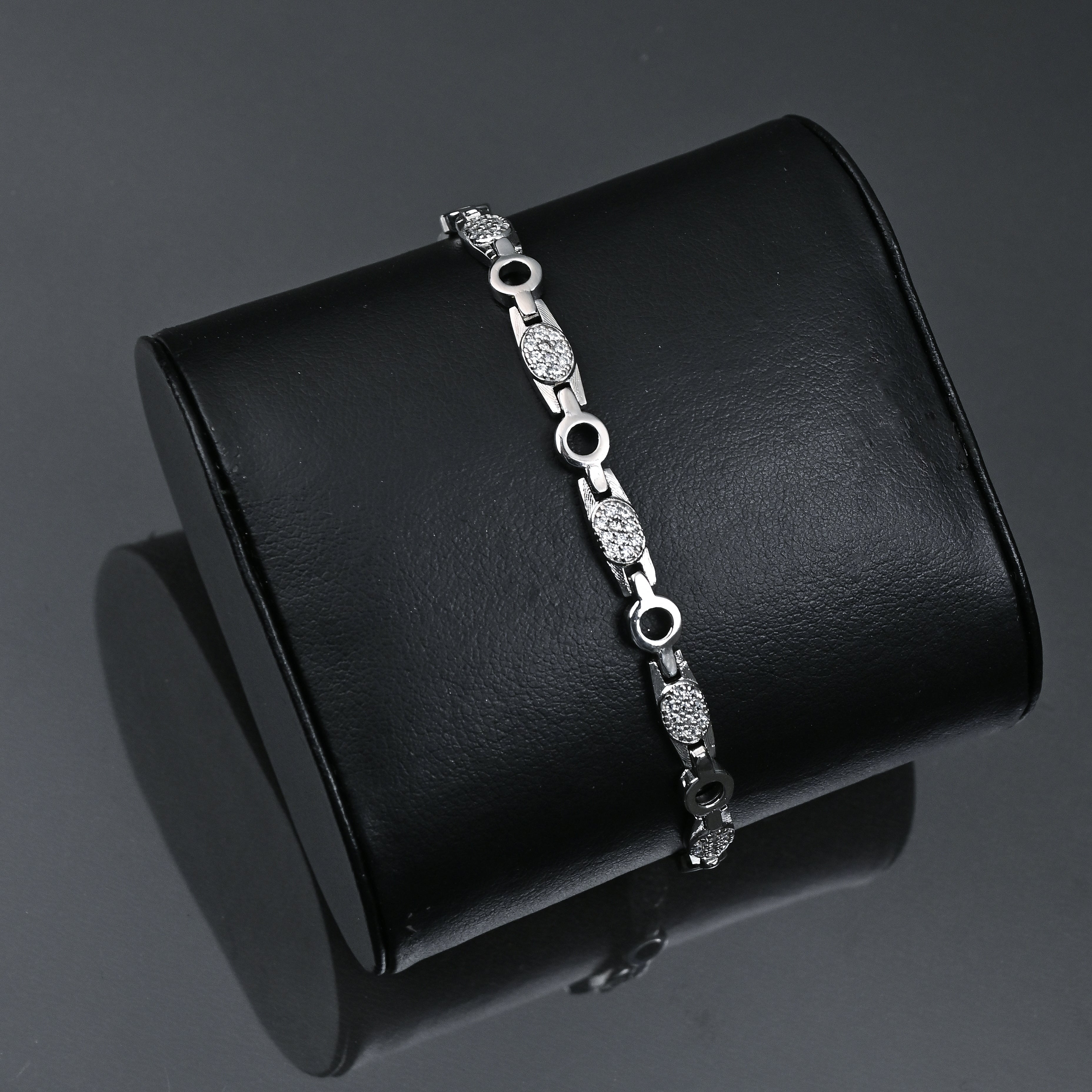 Silver bracelet on a black jewelry box with 'TRISHNHA' branding.
