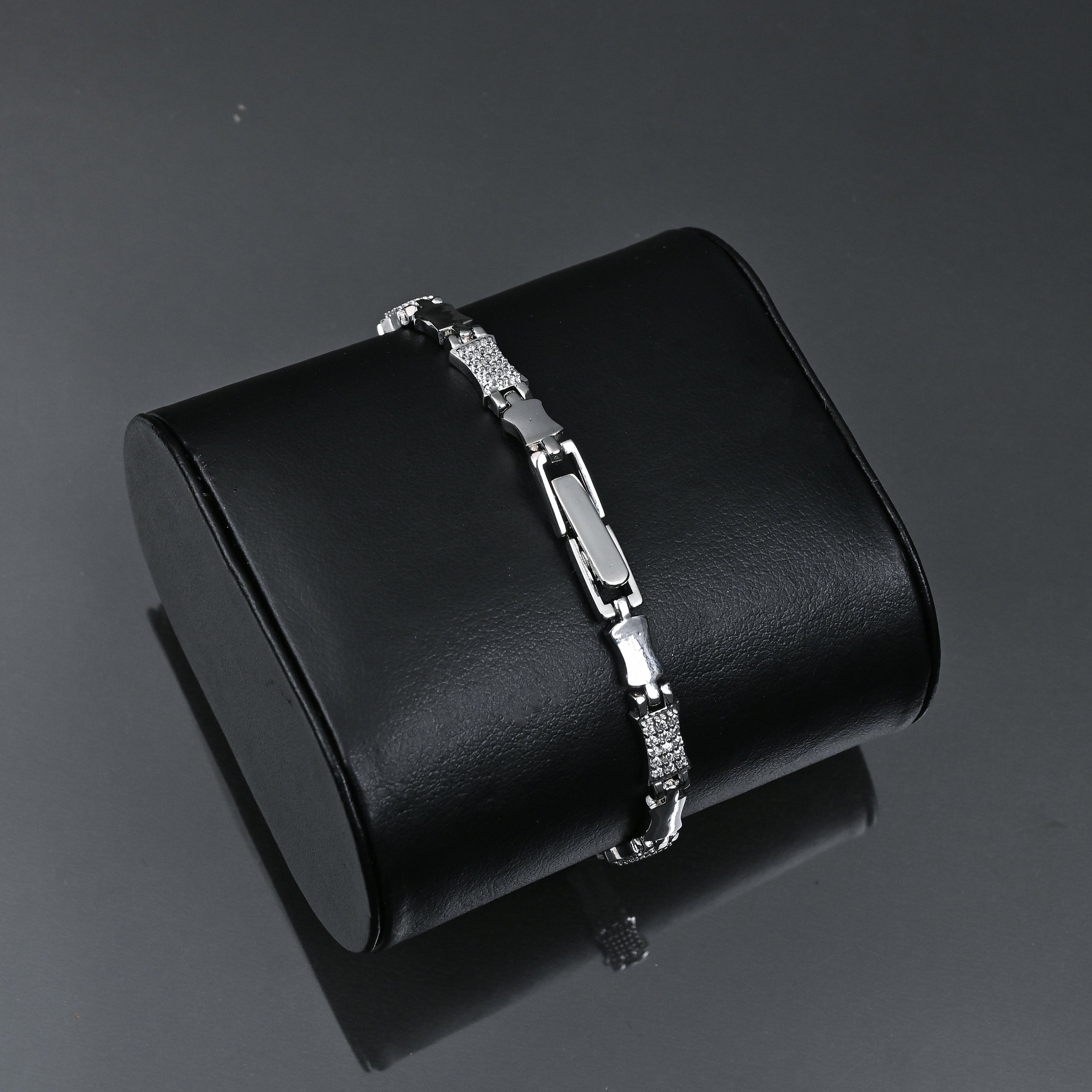 Silver bracelet on a black jewelry box with 'TRISHNHA' branding on a dark background