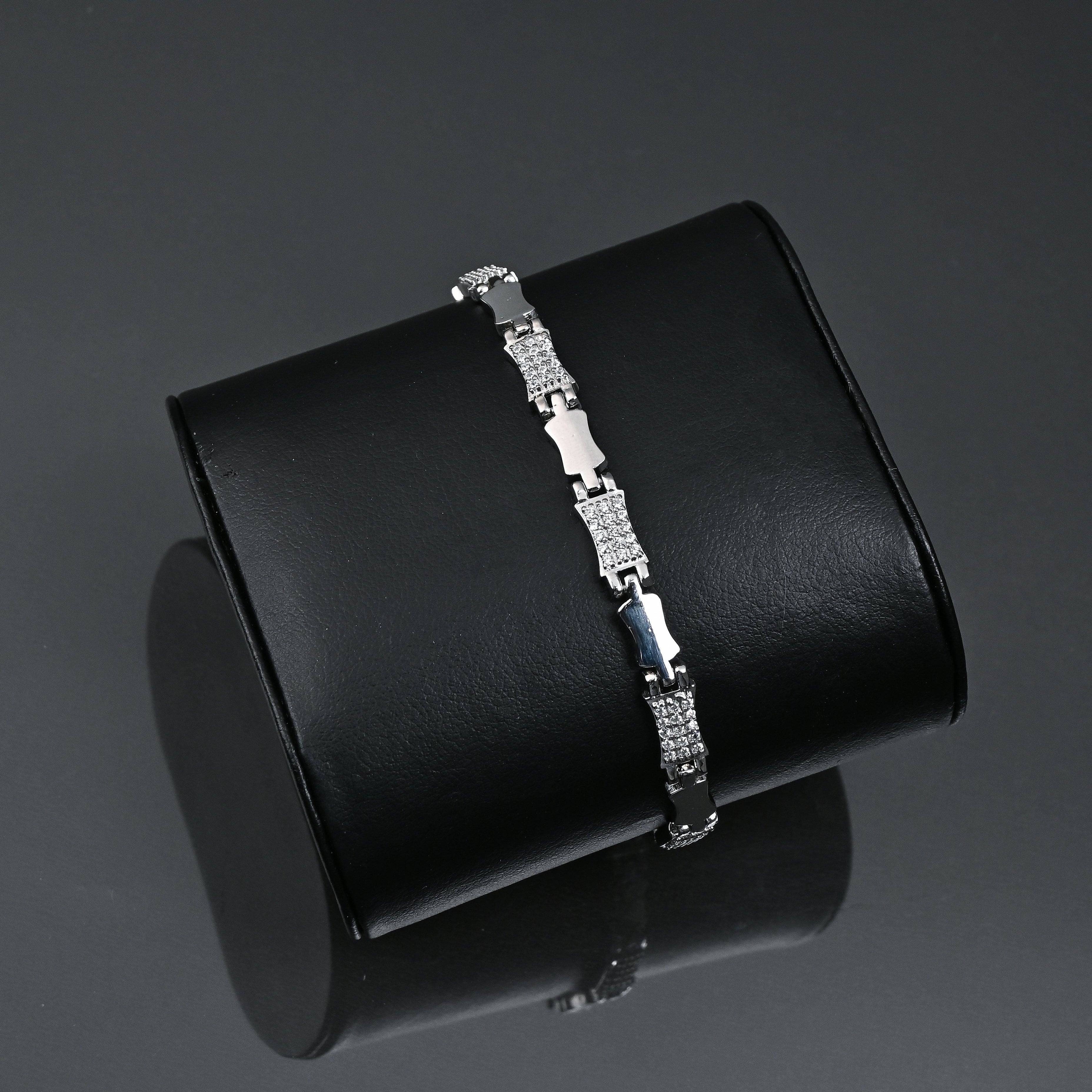 Silver bracelet on a black box with 'TRISHNHA' branding on a dark background