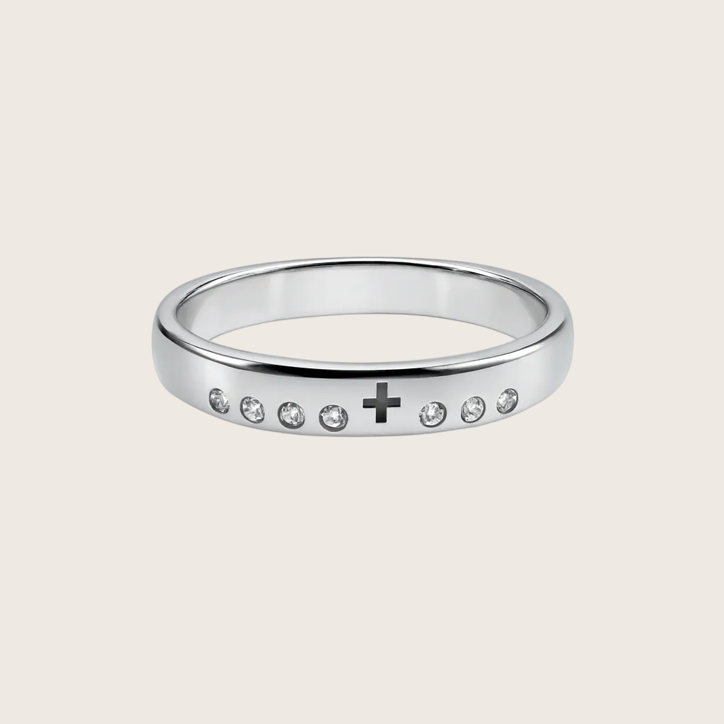 Silver ring with small stones and a cross symbol on a white background