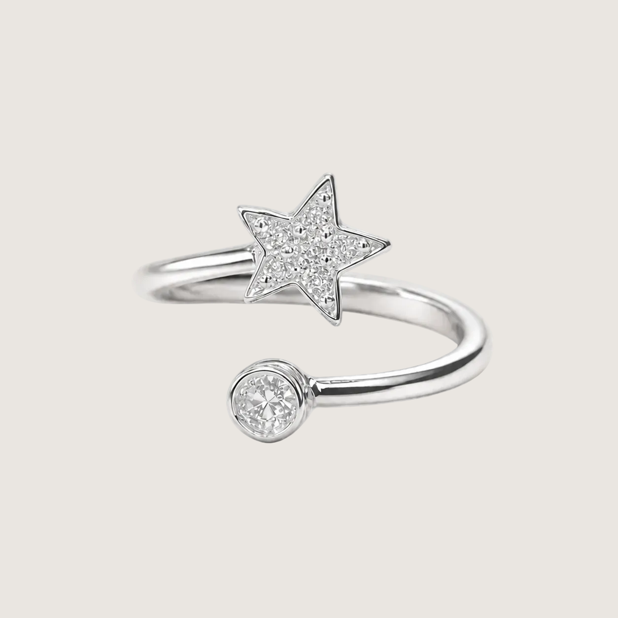 Silver ring with star and round diamond design on a light beige background