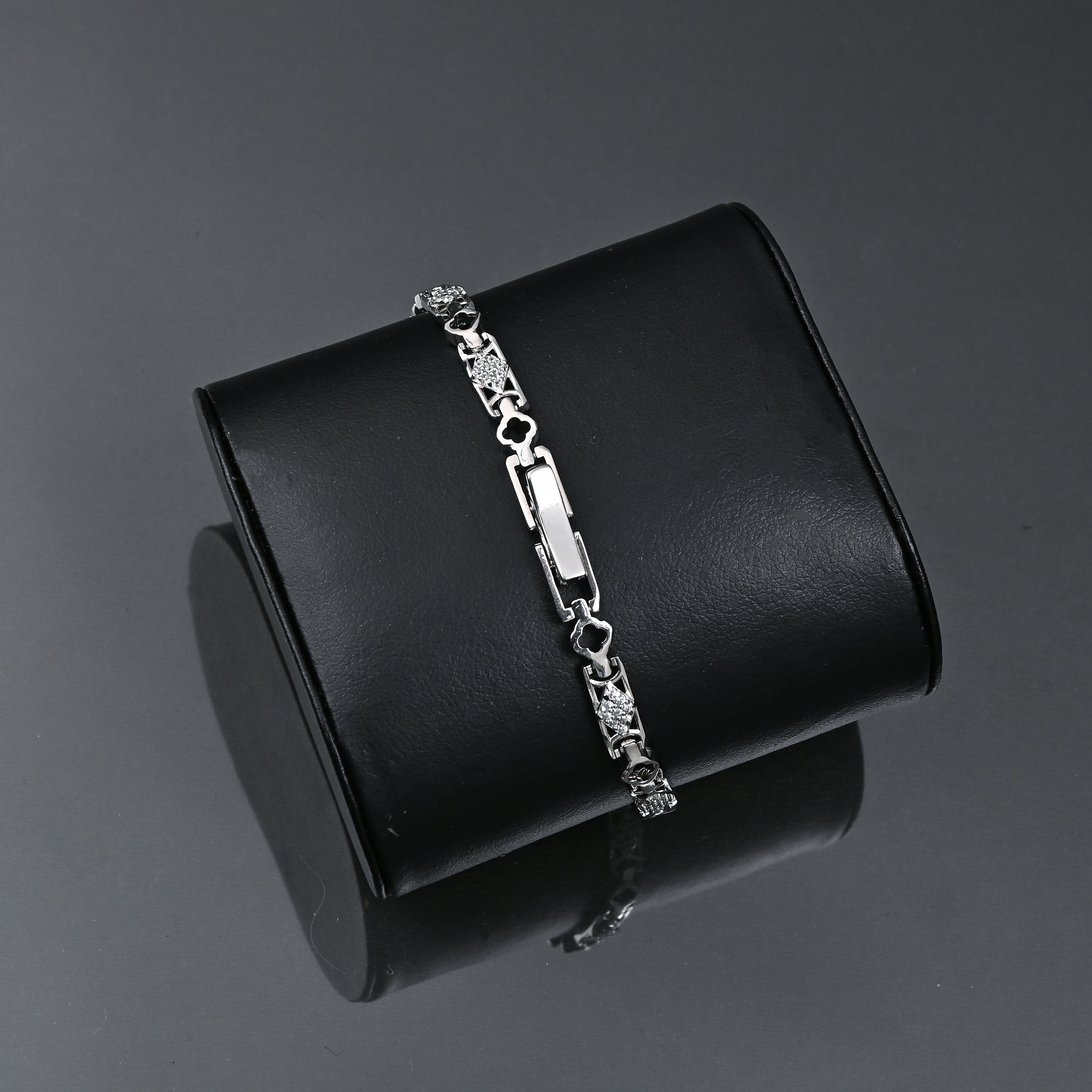 Silver bracelet on a black stand with 'TRISHNHA' branding on a dark background