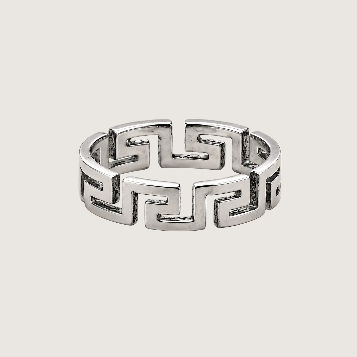 Silver ring with a geometric pattern on a beige background