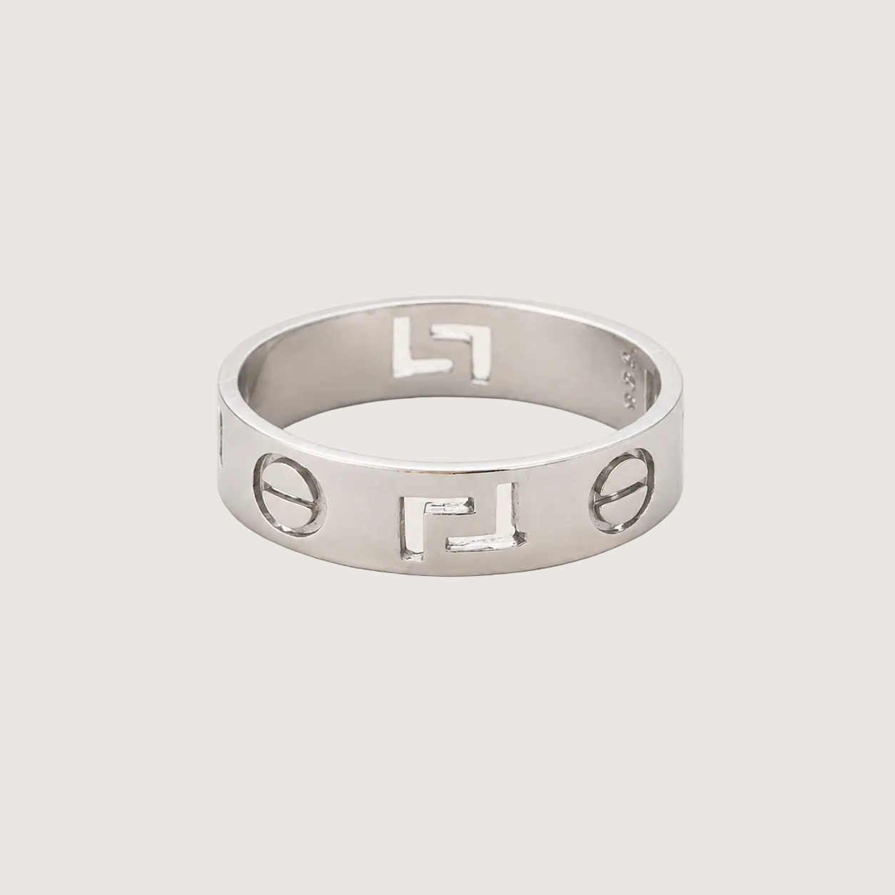 Silver ring with engraved symbols on a light gray background