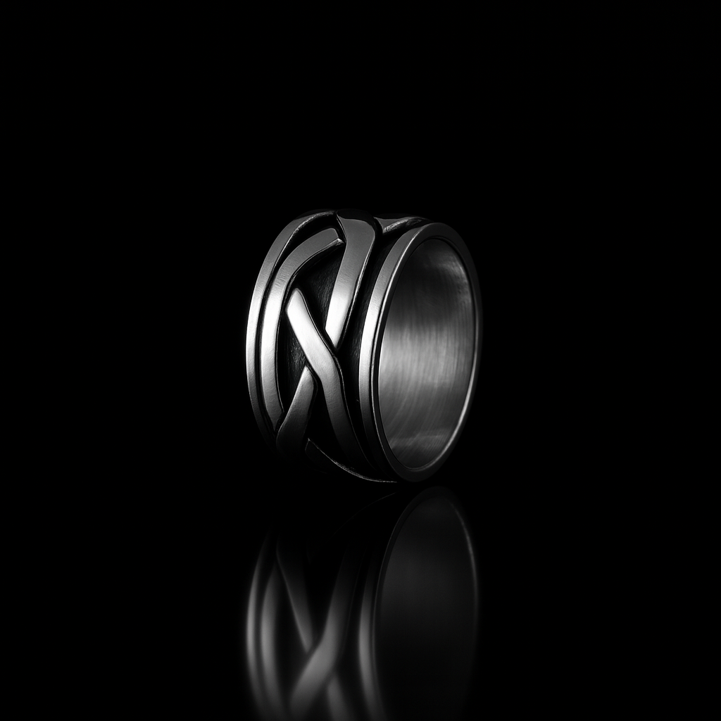 Silver ring with intricate design on a black background
