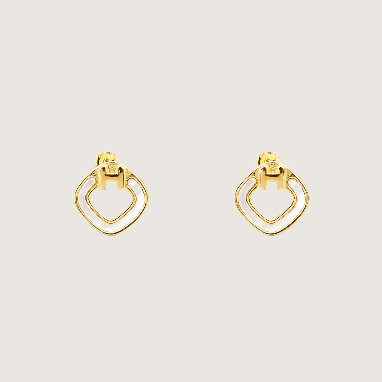 Gold hoop earrings on a beige background
