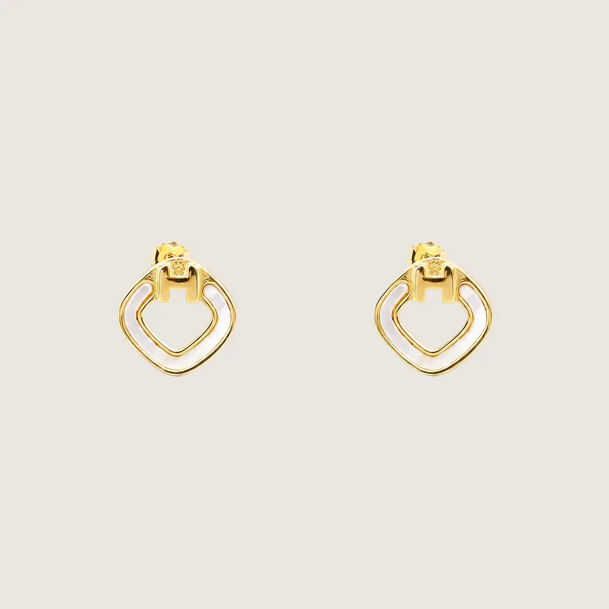 Gold hoop earrings on a beige background