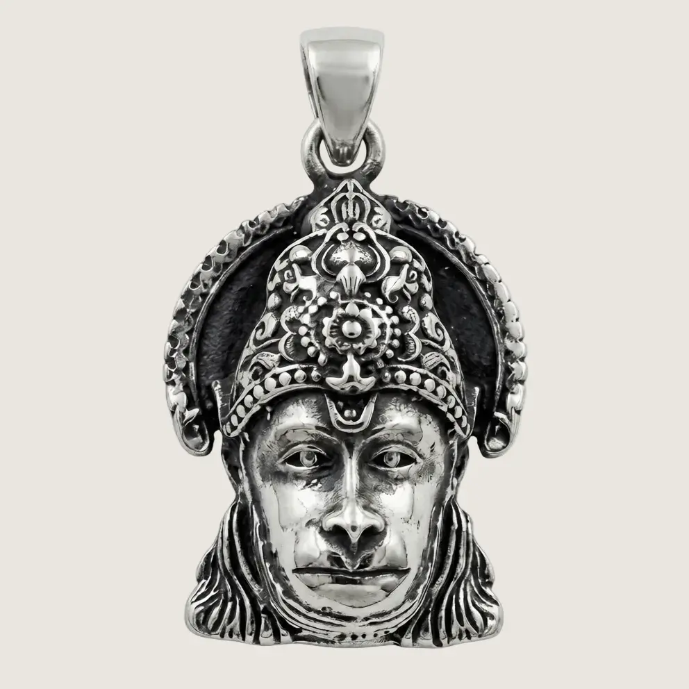 Silver pendant with intricate design on a beige background