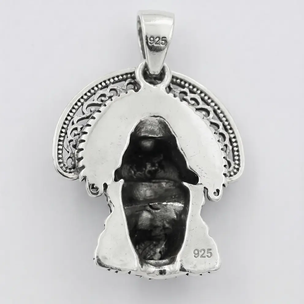 Silver pendant with a face design on a white background