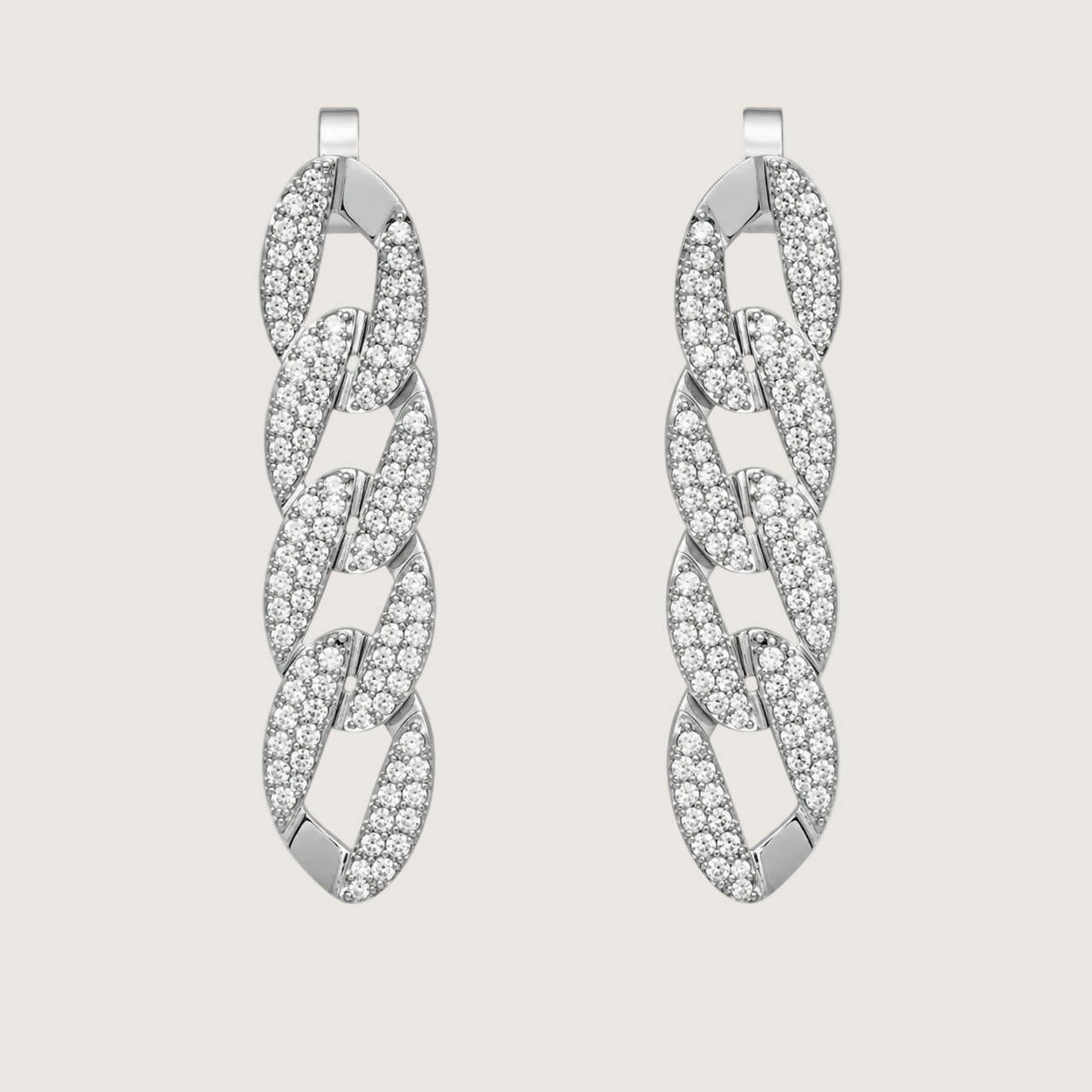 Pair of silver earrings with diamond-like stones on a light gray background
