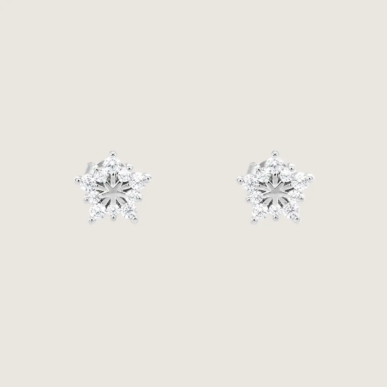 Pair of diamond snowflake earrings on a white background