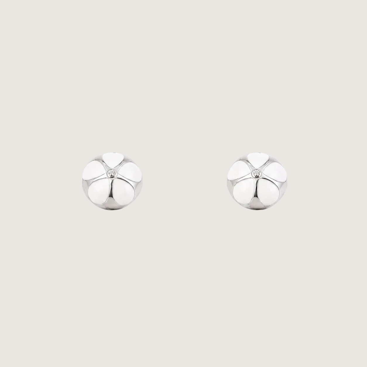 Pair of silver earrings on a light beige background