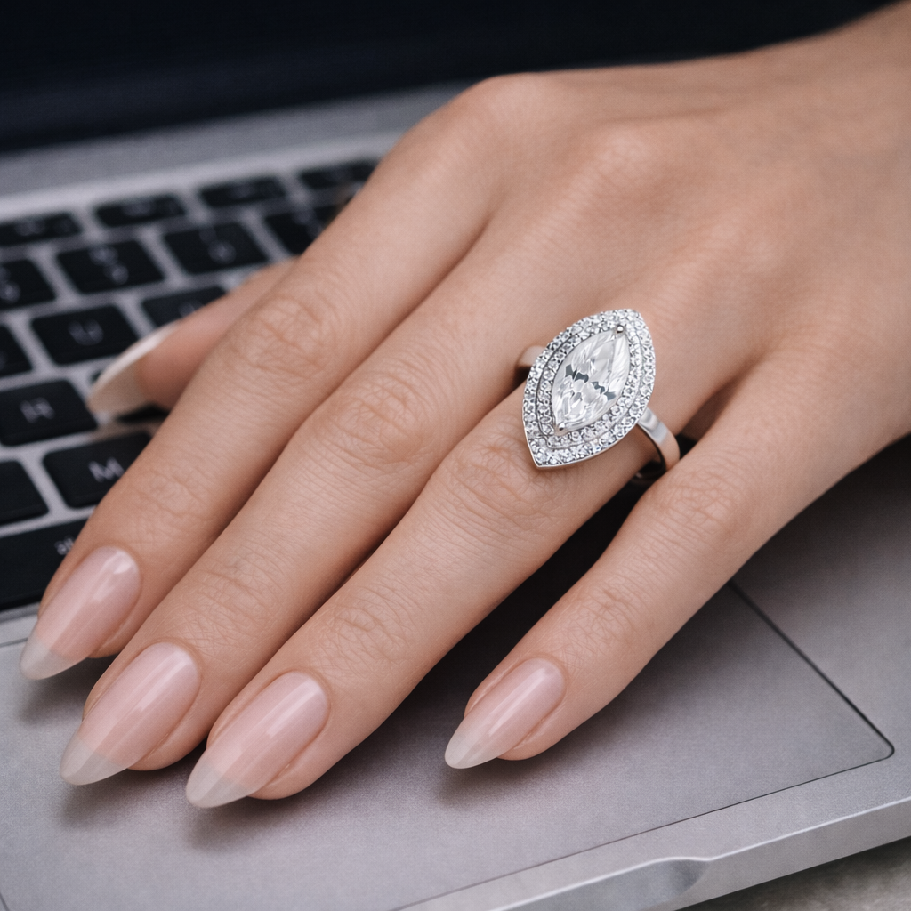 Hand wearing a diamond ring on a laptop keyboard