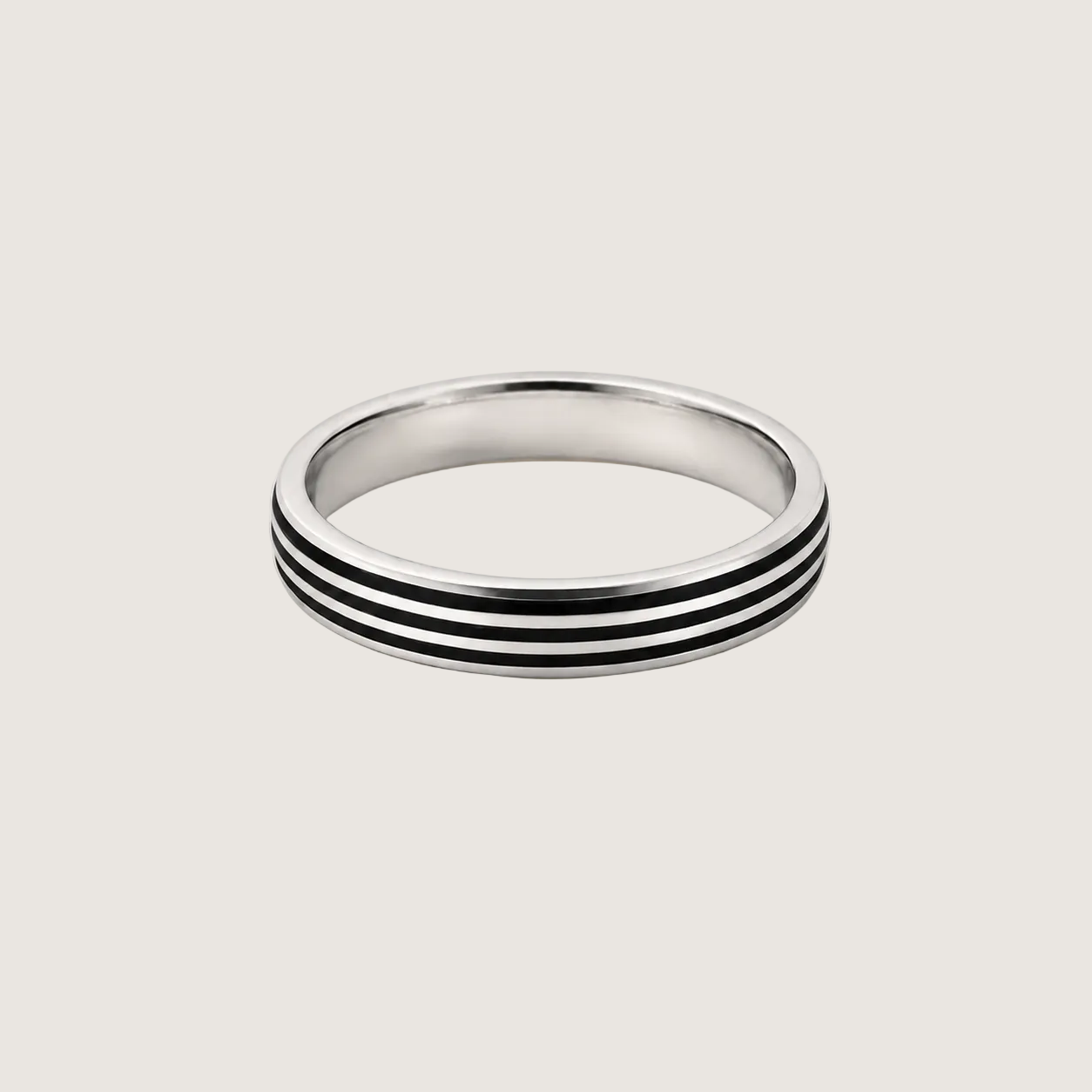 Silver ring with black stripes on a light beige background
