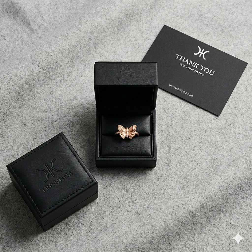 Jewelry box with a butterfly-shaped earring and a 'Thank You' card on a gray surface.
