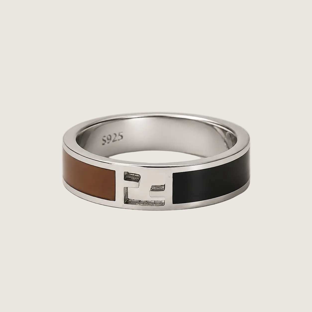 Silver ring with brown and black inlay on a light beige background