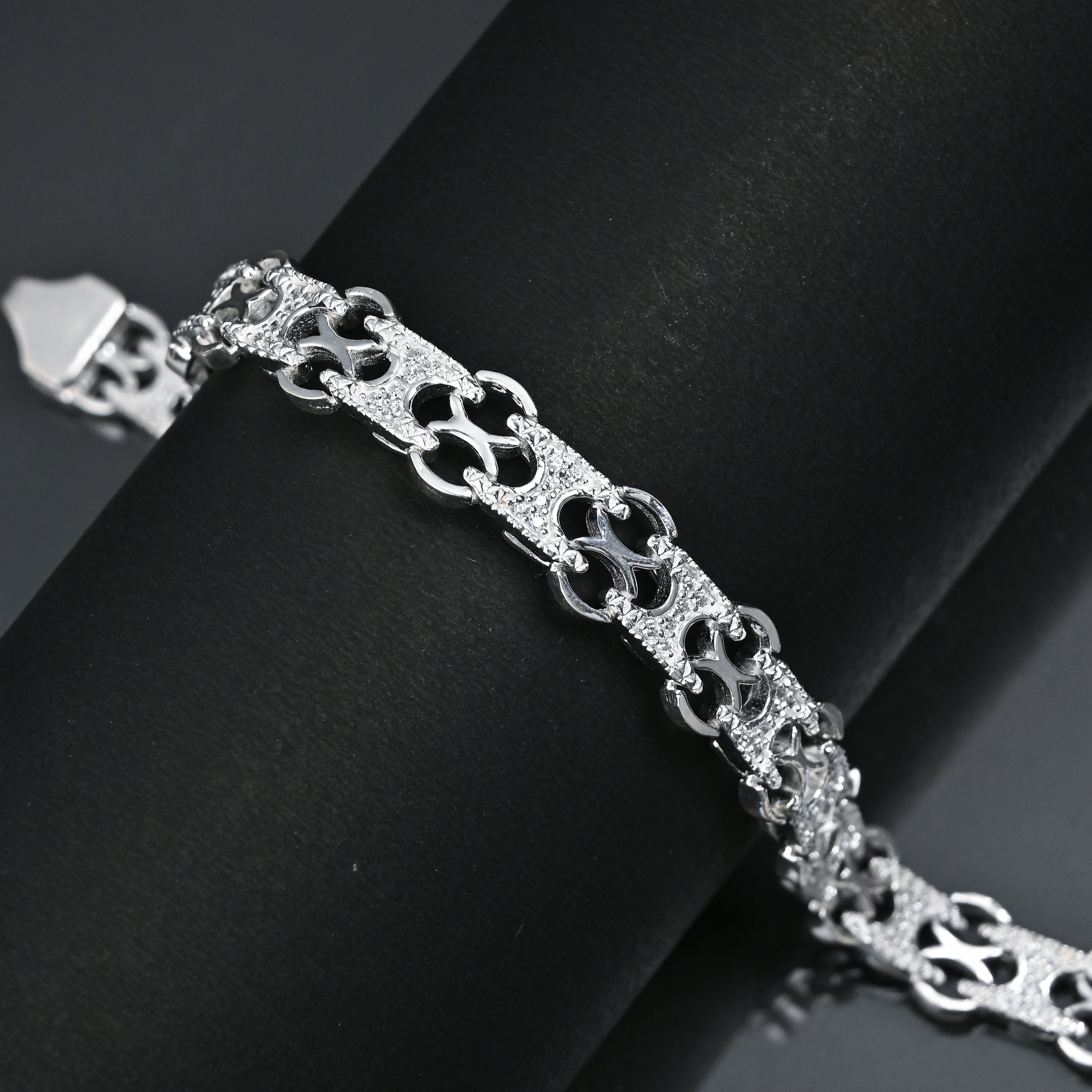 Silver bracelet on a black surface with 'TRISHNHA' branding.
