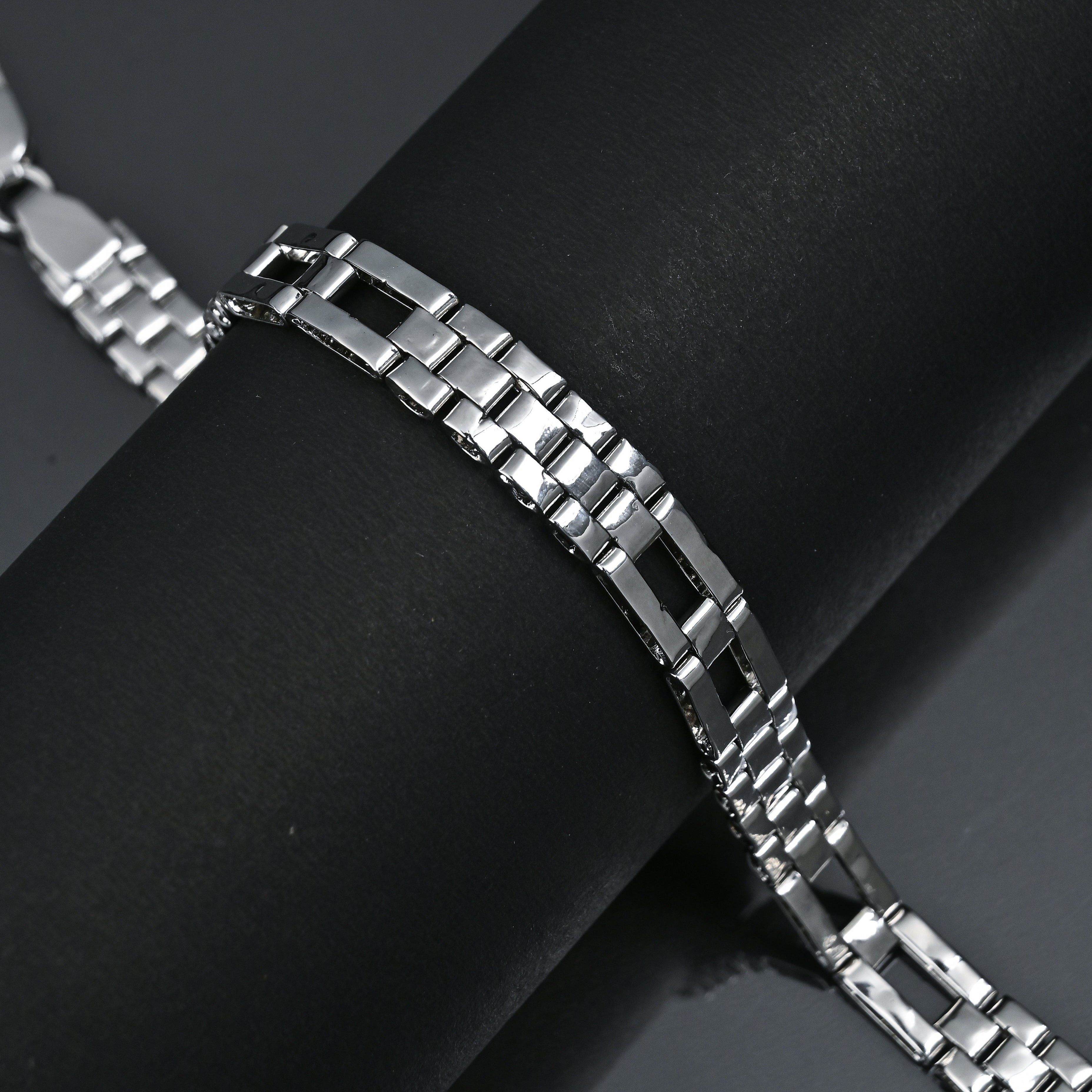 Silver bracelet on a black surface with 'TRISHNHA' branding.