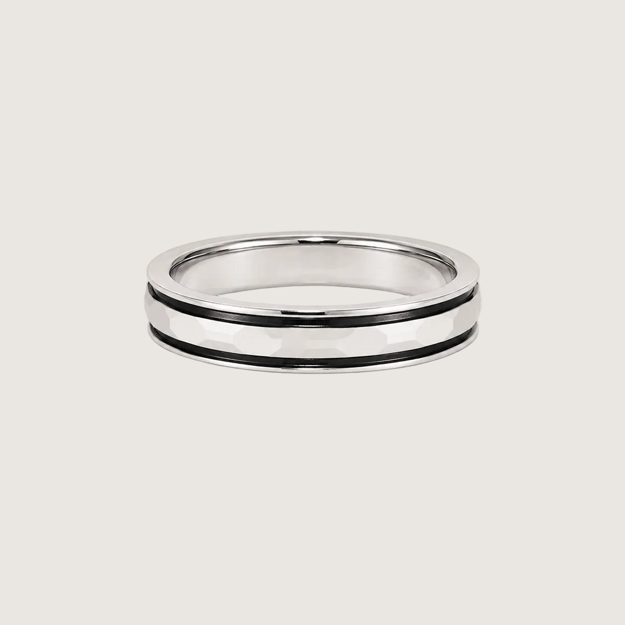 Silver ring with black inlay on a beige background